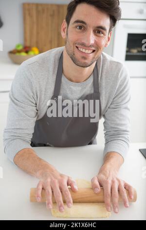 uomo che arrotola la pasta Foto Stock