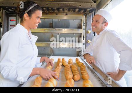 team di panettieri sorridente nella cucina del forno Foto Stock