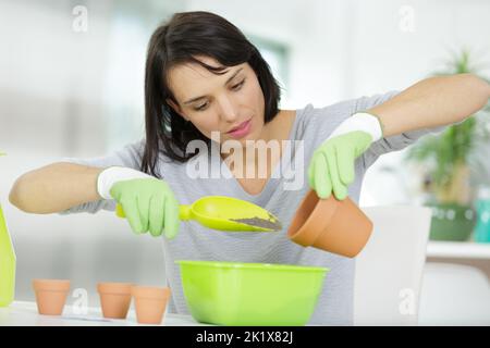 donna vaso fiore in serra Foto Stock