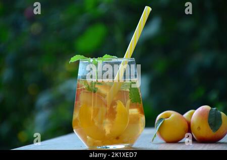 Drink estivi, con cocktail alla menta e alla pesca e ghiaccio in bicchieri. Rinfrescante estate alcolico o non alcolico scarafaggio Detox infuso Foto Stock