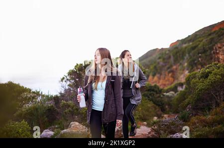 Escursioni con il mio migliore amico. Due giovani donne attraenti escursionisti all'aperto. Foto Stock