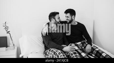Coppia di uomini gay felici che hanno momenti teneri a casa - Focus sulla faccia destra - montaggio in bianco e nero Foto Stock