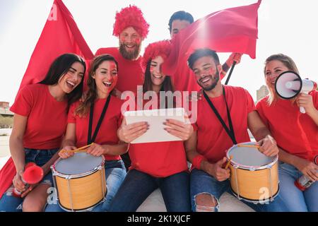 Tifosi pazzi che guardano il calcio su un tablet - concentrati sul volto femminile centrale Foto Stock