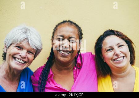 Ritratto delle donne anziane multirazziali che si divertono all'aperto - fuoco sul volto africano della donna Foto Stock