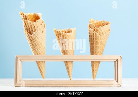 I coni vuoti per cialde al gelato in un supporto in legno Foto Stock