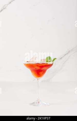 Bevanda alcolica con succo di pomodoro in un bicchiere con primo piano su ghiaccio su sfondo bianco Foto Stock