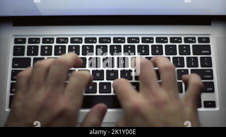 L'uomo d'affari si affida alla tastiera del computer portatile. Le mani toccano la digitazione puntando i dati cloud social network media, estrema primo piano umano mani sul keybo Foto Stock