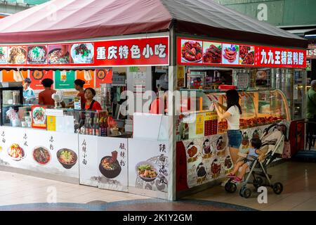 Donna acquistare cibo da strada stallo a Chinatown, Singapore Foto Stock