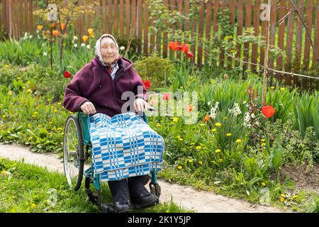Donna anziana seduta su una sedia a rotelle che sembra triste e preoccupato: Depressione, assistenza sanitaria e cura per gli anziani Foto Stock