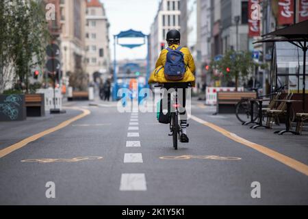 Berlino, Germania. 21st Set, 2022. Solo pochi ciclisti sono sulla strada da parte di Friedrichstraße che è chiusa al traffico automobilistico. La chiusura è stata istituita nel quadro di un progetto pilota temporaneo. I politici hanno voluto aumentare la qualità della vita in questo modo. Ma nel frattempo c'è un'alleanza d'azione di vari imprenditori che chiedono che la chiusura venga revocata. Gli operatori del negozio si lamentano della diminuzione del numero di clienti e quindi di minori entrate. Credit: Paul Zinken/dpa/Alamy Live News Foto Stock