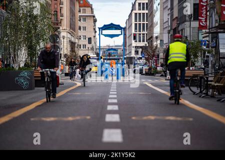 Berlino, Germania. 21st Set, 2022. Solo pochi ciclisti sono sulla strada da parte di Friedrichstraße che è chiusa al traffico automobilistico. La chiusura è stata istituita nel quadro di un progetto pilota temporaneo. I politici hanno voluto aumentare la qualità della vita in questo modo. Ma nel frattempo c'è un'alleanza d'azione di vari imprenditori che chiedono che la chiusura venga revocata. Gli operatori del negozio si lamentano della diminuzione del numero di clienti e quindi di minori entrate. Credit: Paul Zinken/dpa/Alamy Live News Foto Stock