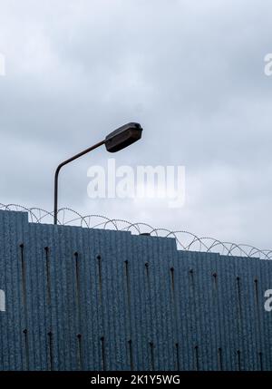 Recinzione di alta sicurezza della prigione sormontata da filo razer. Foto Stock