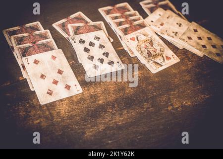 Mazzo di carte che gioca una partita di 'pazienza' su un tavolo di legno. Foto Stock