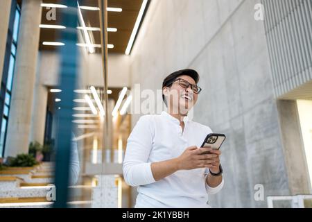 Sorridente giovane utilizzando il telefono cellulare Foto Stock