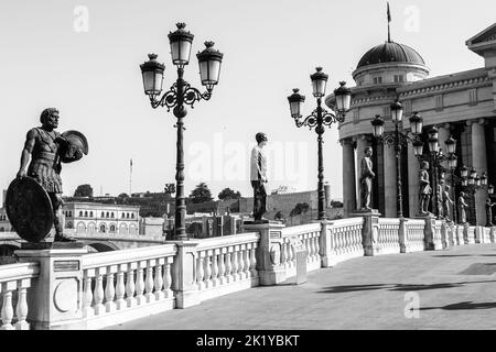 Statue che decorano il Ponte delle civiltà, di fronte al Museo Archeologico di Skopje, Macedonia settentrionale. Ponte che attraversa il fiume Vardar, in estate. Foto Stock