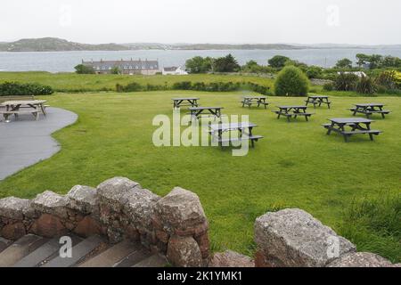 Una vista dell'oceano dalla tenuta con panchine sull'erba sull'Isola di Iona, Scozia Foto Stock