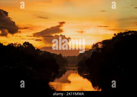 Una serata incredibilmente bella quando il rosso scuro, il giallo e il nero si illuminano nelle nuvole. Gli uccelli sono tornati al nido. Gli alberi sono cov Foto Stock