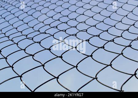 Primo piano in maglia metallica contro il cielo blu. Il concetto di libertà e di pace. Foto Stock