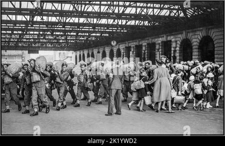 TRUPPE D'EVACUAZIONE WW2 Waterloo Station Londra con le truppe in arrivo per andare in guerra con la Germania nazista mentre i bambini vengono inauguri ed evacuati da Londra partono per l'area di ricevimento. Ai treni evacuati lontano dal blitz bombardamento di Londra. Cab Road, stazione di Waterloo, Londra, Inghilterra. Foto Stock