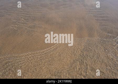 INCRESPATURE NELLA SABBIA FOTOGRAFATA ATTRAVERSO L'ACQUA DI MARE Foto Stock