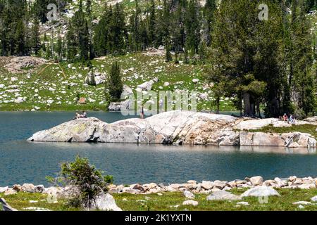 Wyoming, USA - 21 luglio 2022: Gli escursionisti si rilassano su un affioramento roccioso al Lago Solitude nel Parco Nazionale di Grand Teton Foto Stock