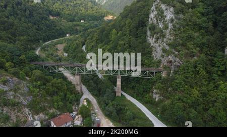 Vista dall'alto di un vecchio ponte ferroviario collegato ad un tunnel su una montagna