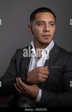 studio shot indossando una camicia bianca e giacca tuta un giovane latino con capelli corti, uomo d'affari e stile di vita moderno, abbigliamento formale Foto Stock