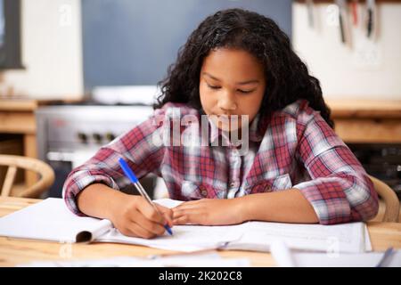 Cessa uno studente concentrato. Una giovane ragazza che studia alla scrivania in un'aula. Foto Stock