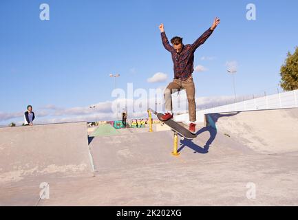 Avete visto le abilità su questo. Un giovane che fa dei trucchi sul suo skateboard al parco skate. Foto Stock