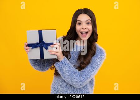 Stupito adolescente. Regalo emotivo bambino adolescente tenere il compleanno. Ragazza capretto divertente che tiene le scatole del regalo che festeggia il nuovo anno felice o Natale. Eccitato Foto Stock