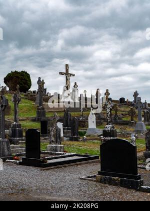 West Cork, Irlanda, 2 maggio 2022. Un cimitero cattolico in una giornata nuvolosa. Pietre tombali in pietra. Cimitero di Darrara nella contea di Cork, Irlanda. Headstone Foto Stock