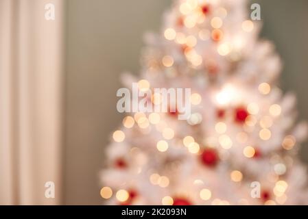 Luci luminose su un albero di Natale. Foto sfocata di un albero di Natale splendidamente decorato. Foto Stock