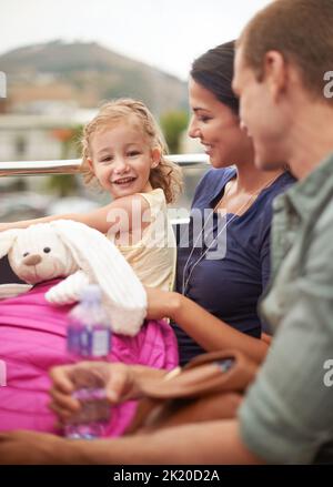 Prima volta in autobus. Ritratto di una bambina seduta sull'autobus con la sua famiglia. Foto Stock