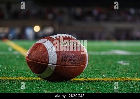 Primo piano di un calcio Wilson su un prato artificiale durante una partita di calcio notturna. Foto Stock