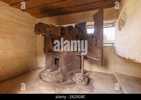 Vecchia arrugginita pistola tedesca della guerra mondiale 2 in bunker a Omaha Beach, Normandia, Francia Foto Stock