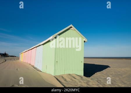 Capanne multicolore sulla spiaggia deserta di Berck in Francia Foto Stock