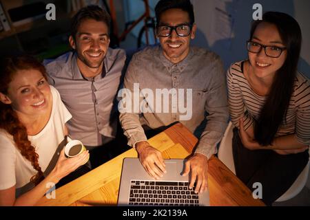 Non ci dispiace lavorare tardi, colleghi che lavorano la sera in ufficio. Foto Stock