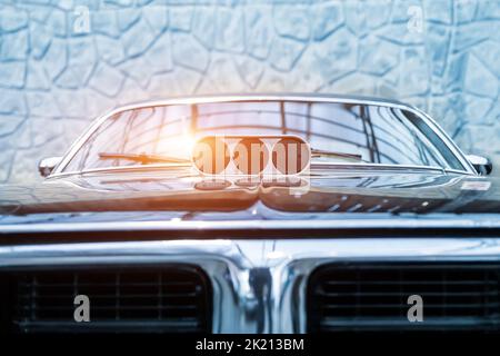 Vista ravvicinata dei dettagli della vecchia vecchia vecchia auto supercharged americana retrò rossa della valvola a farfalla di aspirazione sul cofano trombe cromate montate Foto Stock