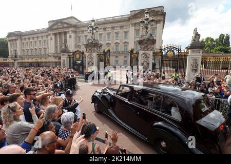 La regina Consort Camilla entra a Buckingham Palace circondato da bravoloni e da tifosi reali alle porte di questo pomeriggio. La nazione continua a mour Foto Stock