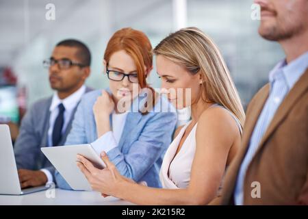 Lavoro di squadra con la tecnologia. Due uomini d'affari che leggono grafici su un tablet. Foto Stock