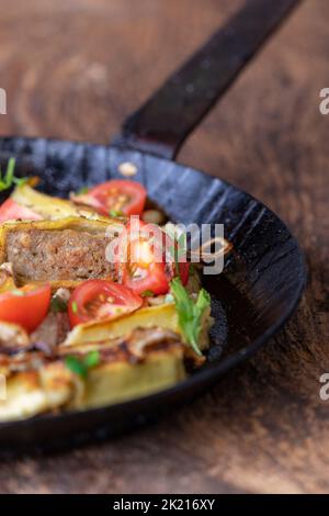 Maultasche sveva con le cipolle in una padella di ferro Foto Stock