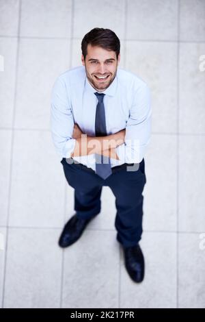 Puntando verso la parte superiore. Ritratto ad angolo alto di un giovane uomo d'affari bello e sicuro. Foto Stock