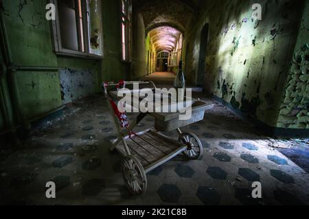 Un vecchio carrello medico in piedi nel corridoio di un ospedale sovietico abbandonato Foto Stock
