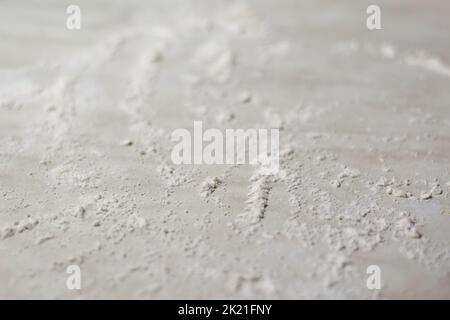 Sfocare lo sfondo astratto. Cosparso di farina di grano circolare, punto rotondo su sfondo bianco. Vista dall'alto sulla lavagna. Concetto di cottura, cottura di pasta o pa Foto Stock