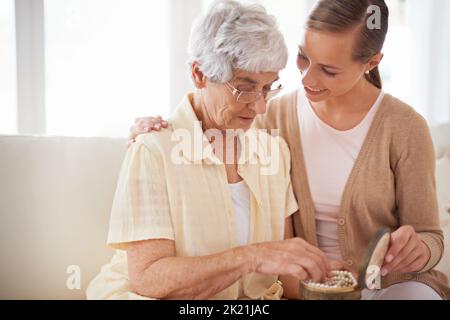 Questo è il loro heirloom di famiglia. Una donna anziana che dà a sua figlia una collana di perle. Foto Stock