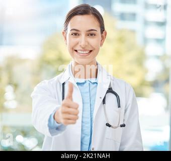 Sì, il successo del medico e la ringrazio pollici su di una donna con un vincitore, felice e segno di mano di sostegno. Ritratto di un operatore medico, sanitario e clinico Foto Stock