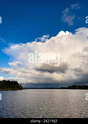 Nuvole di pioggia in lontananza sul lago Nokomis a Tomahawk, Wisconsin, verticale Foto Stock