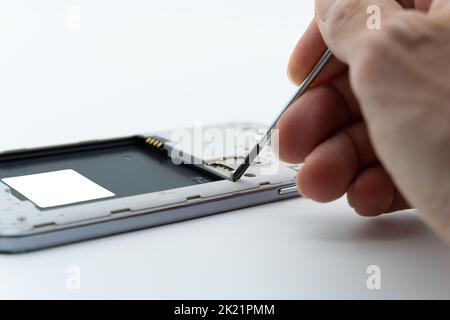 La situazione di riparazione di un telefono cellulare con un cacciavite Foto Stock