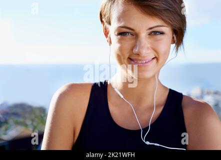 Ama allenarsi al mattino, una giovane donna sportiva che ascolta la musica fuori. Foto Stock