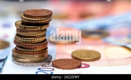 Torre con monete e banconote in euro sullo sfondo, primo piano Foto Stock